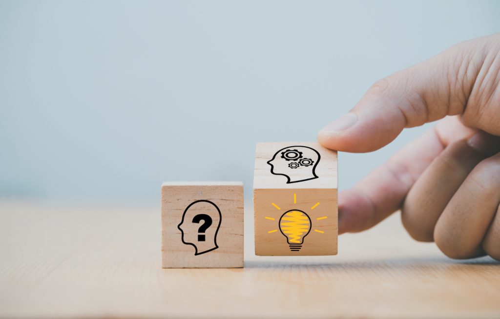 Hand hält zwei Würfel mit Symbolen für Fragezeichen und leuchtende Glühbirne. Text: "Häufig gestellte fragen zur Insel Krk" und Button "zum FAQ bereich".