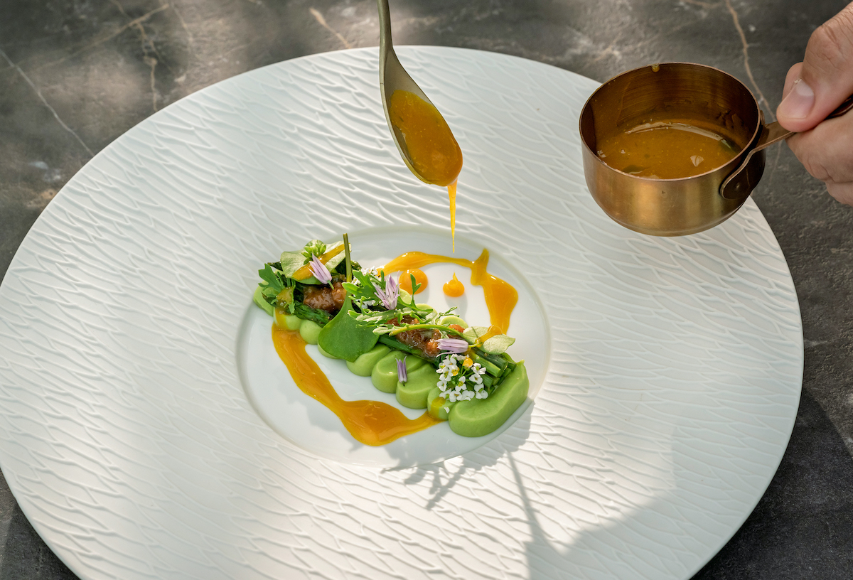 Chefkoch vollendet das Gericht mit pikanter Sauce