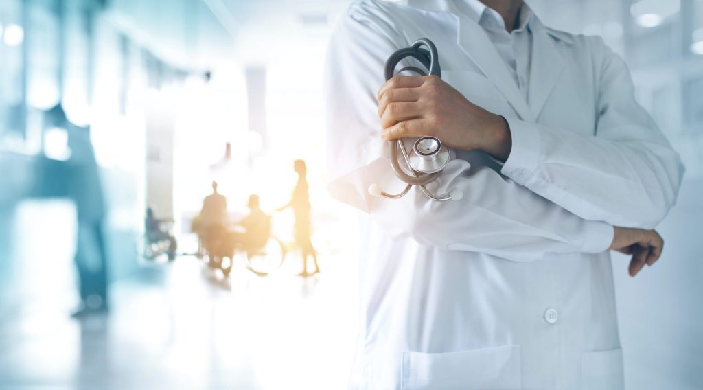 Ein Arzt in weißem Kittel steht in einem modern ausgestatteten Behandlungszimmer eines Krankenhauses auf der Insel Krk.