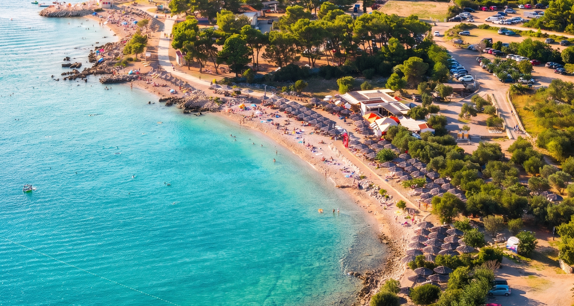 Gepflegte Rasenfläche mit Olivenbäumen und Sonnenliegen an der Medane Beach Bar in Punat auf Krk.