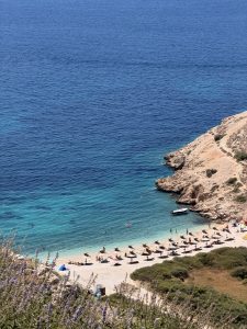 Blick von oben auf den Oprna Beach bei Stara Baška auf der Insel Krk mit Badegästen und Booten im türkisen Wasser.