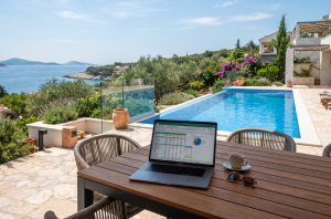 Ein Tablet zeigt einen interaktiven Rendite-Rechner für Ferienimmobilien, im Hintergrund eine luxuriöse Villa mit Pool auf der Insel Krk in Kroatien.