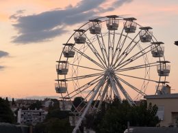 Das beleuchtete Riesenrad in der Stadt Krk bei Nacht mit Blick auf den Hafen.