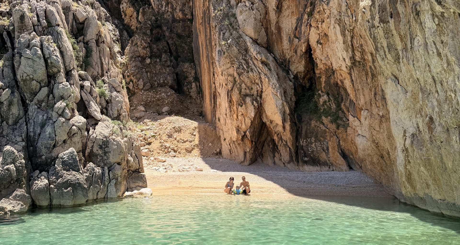 Ansicht vom Boot auf den geheimen Secret Beach Kris auf der Insel Krk mit leuchtend türkisem Wasser.