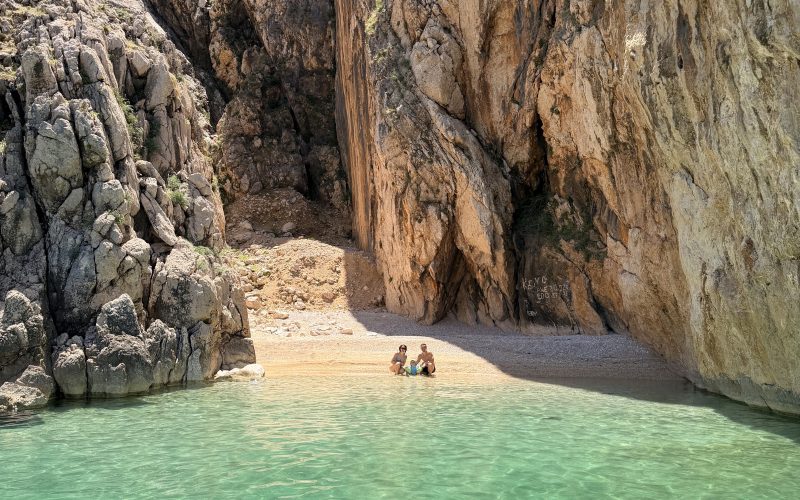 Ansicht vom Boot auf den geheimen Secret Beach Kris auf der Insel Krk mit leuchtend türkisem Wasser.