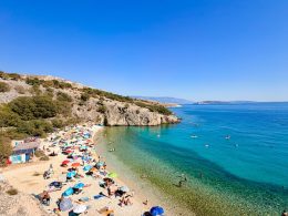 Badebucht Zala auf der Insel Krk mit Beach Bar, türkisblauem Meer durch kühle Süßwasserquellen und Badegästen.