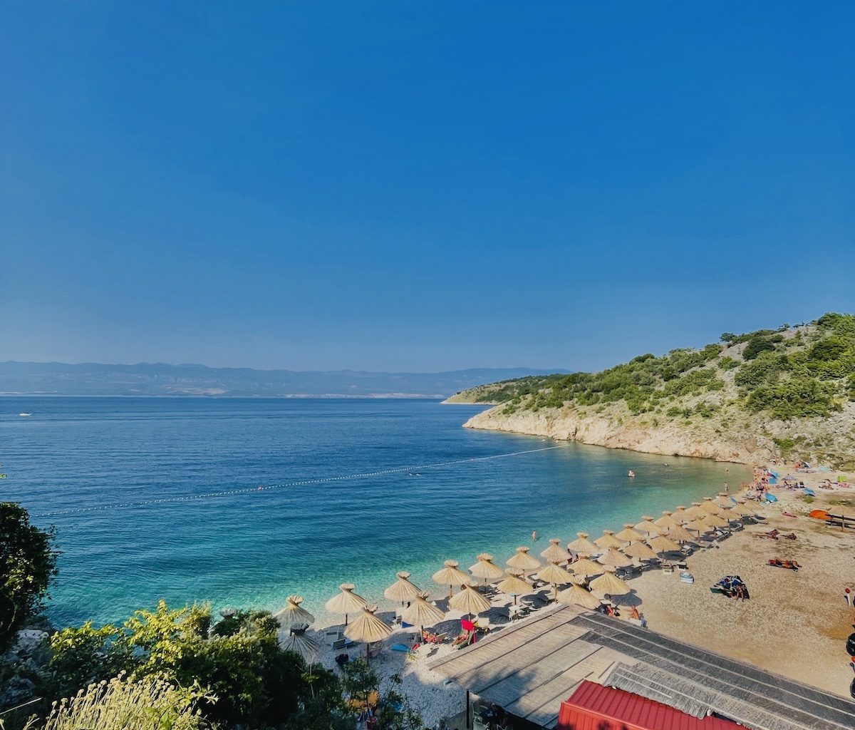 Der naturbelassene Kieselstrand Potovošće nahe der Weinstadt Vrbnik auf der Insel Krk, umgeben von mediterraner Natur und kristallklarem Meer.