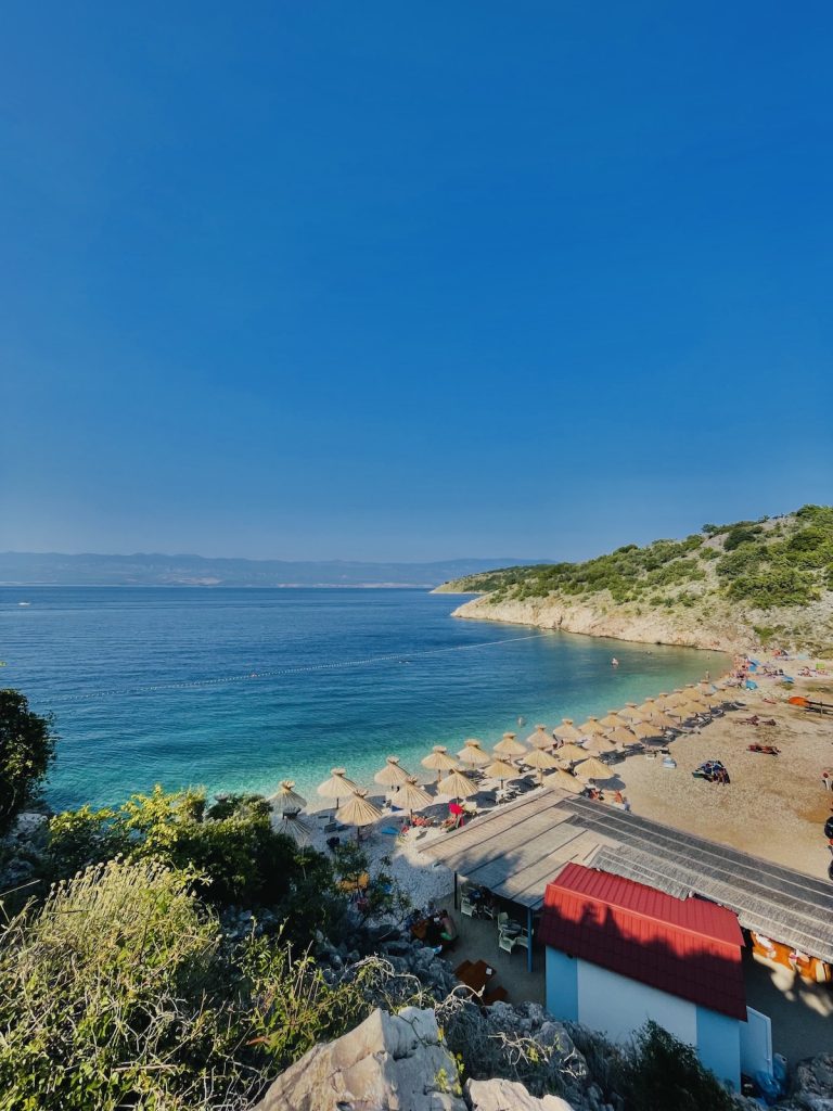 Der naturbelassene Kieselstrand Potovošće nahe der Weinstadt Vrbnik auf der Insel Krk, umgeben von mediterraner Natur und kristallklarem Meer.