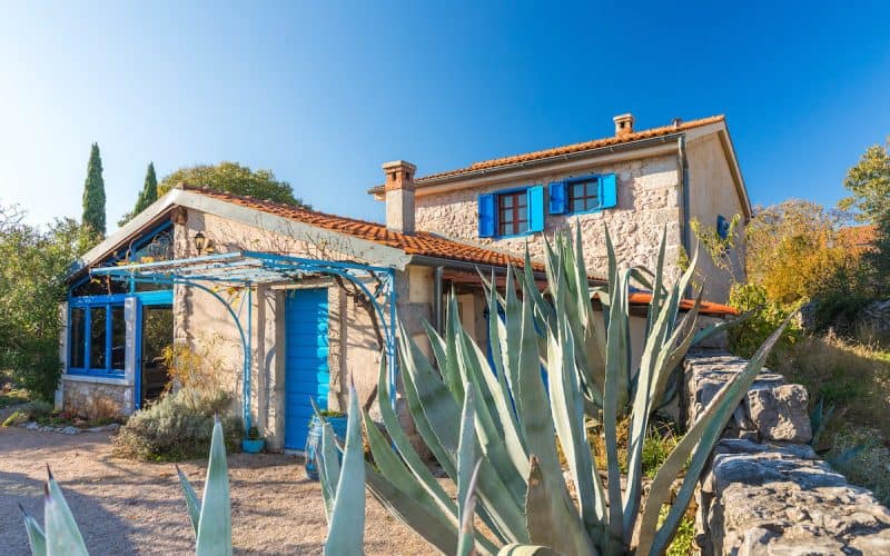 Gemütliches Ferienhaus mit blauen Fensterläden und Garten auf Krk.